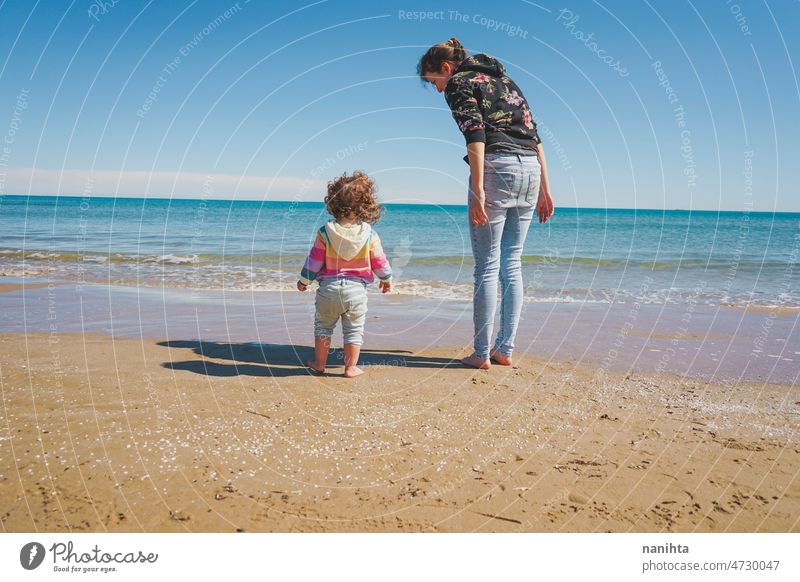 Junge alleinerziehende Mutter, die sich um ihr kleines Mädchen am Strand kümmert Familie Kindererziehung Mama Single respektvolle Kindererziehung erkunden frei