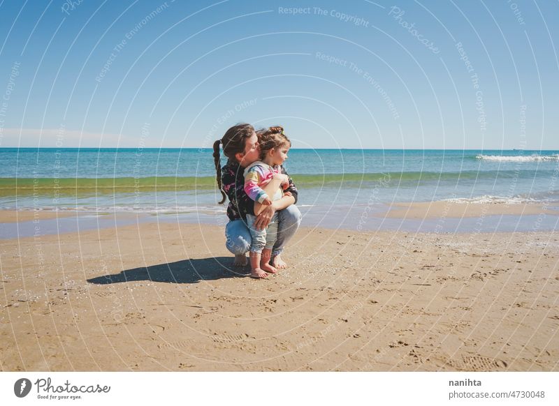 Junge alleinerziehende Mutter, die sich um ihr kleines Mädchen am Strand kümmert Familie Kindererziehung Mama Single respektvolle Kindererziehung erkunden frei