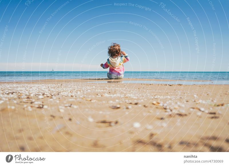Großansicht eines kleinen Mädchens mit Regenbogen-Kapuzenpulli beim Spielen am Strand Freiheit Fröhlichkeit Feiertage Baby Kleinkind Familie frei MEER Ufer