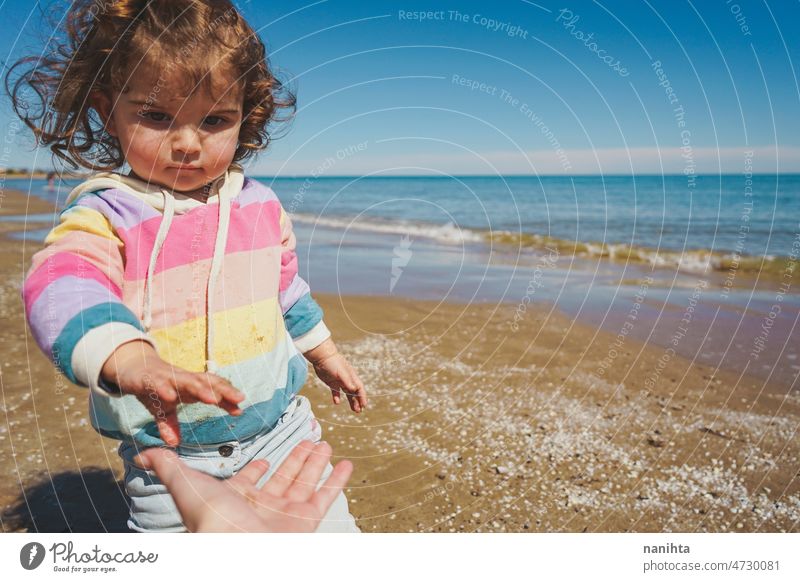 Mittelteil eines kleinen Mädchens beim Spielen am Meer Porträt Baby bezaubernd Strand Sommer lockig Behaarung Freude genießen Kleinkind Regenbogen Süßer