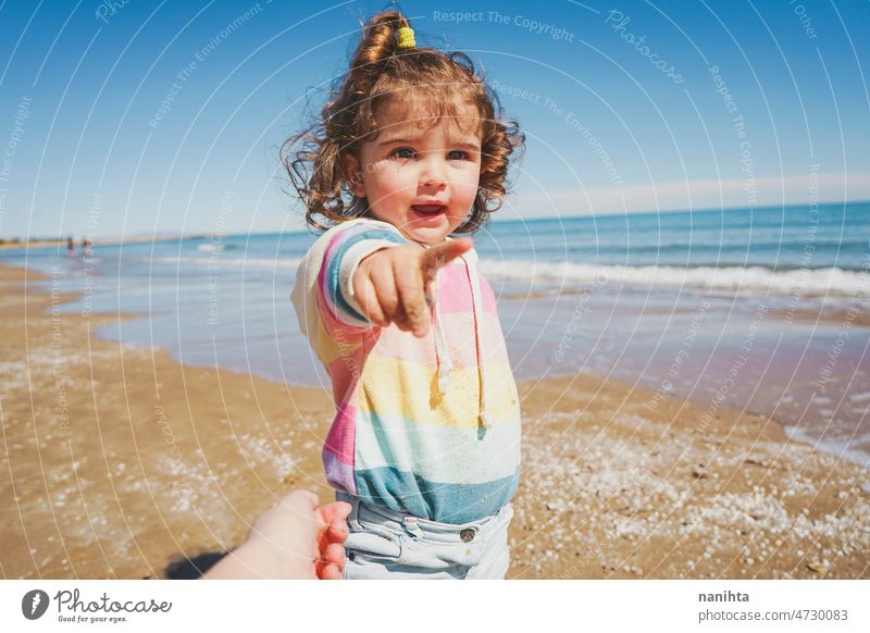 Mittelteil eines kleinen Mädchens beim Spielen am Meer Porträt Baby bezaubernd Strand Sommer lockig Behaarung Freude genießen Kleinkind Regenbogen Süßer