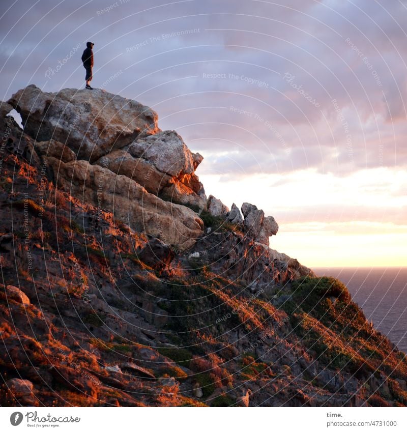 Farbcontest | Morgenlicht Felsen Mann Küste Morgensonne meer reisen unterwegs himmel wolken wanderer stehen beobachten früh morgenlicht sonnig rötlich steine