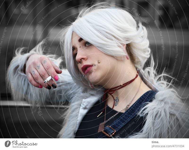 Frau mit Zigarette, nachdenklich feminin lässig cool Künstler Schauspieler Jacke Fell Piercing weißhaarig Haare & Frisuren beobachten festhalten Blick