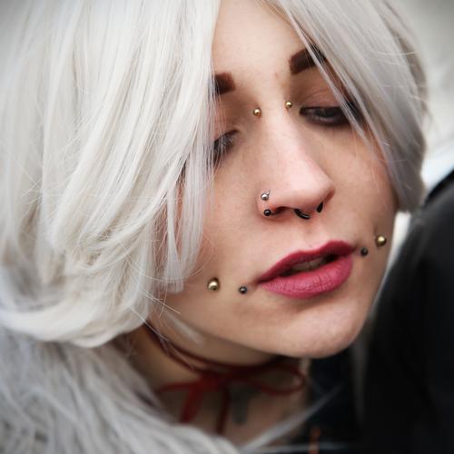 Frau mit Piercings feminin weißhaarig Haare & Frisuren außergewöhnlich Stimmung Gefühle Inspiration Kreativität Porträt Blick nach unten Hingabe nachdenklich