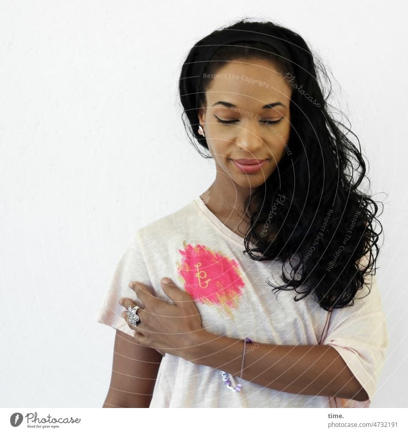 Frau mit Promo-Shirt frau t-shirt schwarzhaarig langhaarig schmuck blick nach unten hand halten
