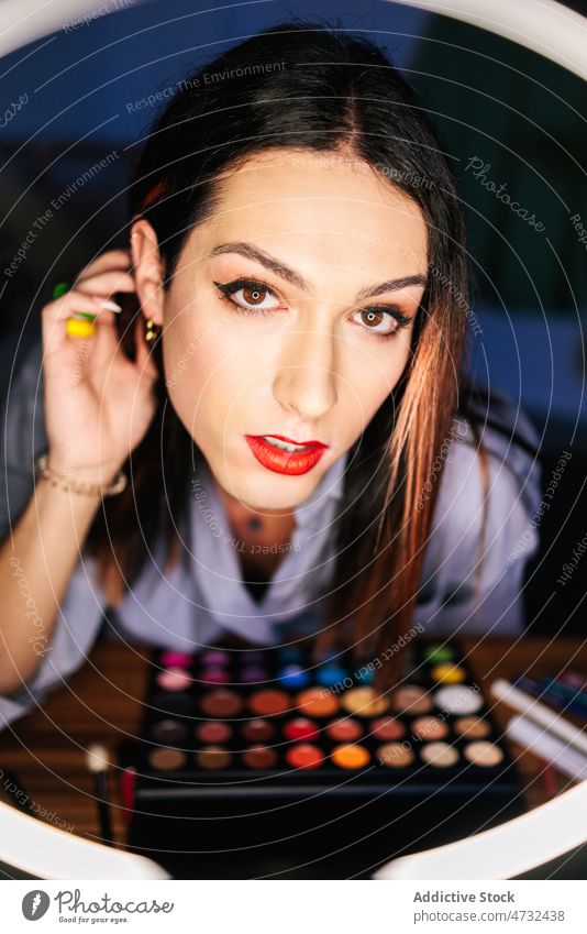 Charmante Frau schaut durch Ringlampe in der Nähe von Lidschatten Blogger Influencer Kosmetik Make-up Gesicht Vorschein Schönheit feminin Licht Dame modern Stil