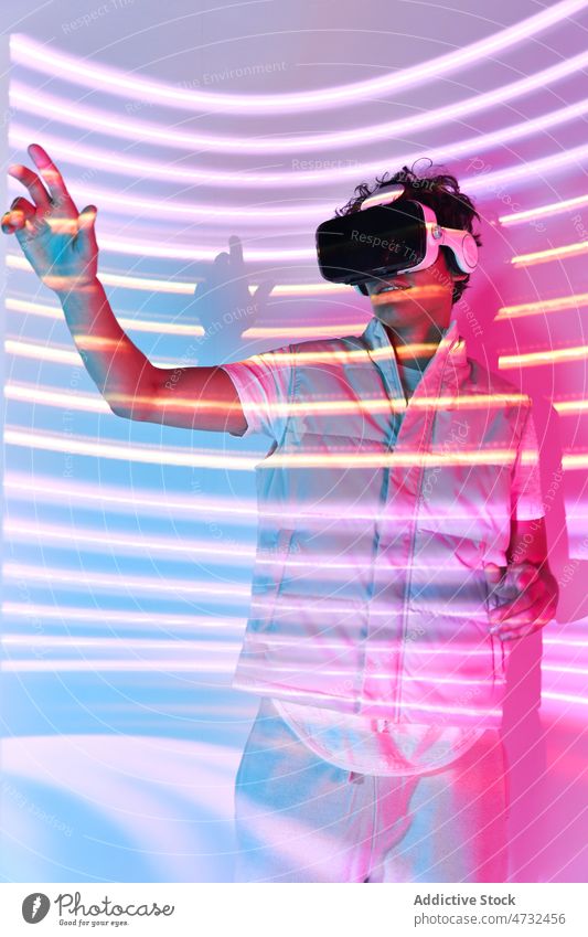 Frontansicht eines nicht erkennbaren Mannes in einem VR-Headset Virtuelle Realität Licht Cyberspace Zukunft Augmented Reality interaktiv Technik & Technologie