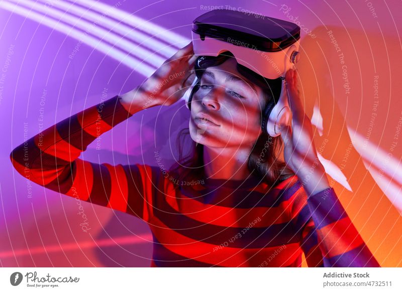 Frau in modernem VR-Headset Virtuelle Realität Licht Cyberspace Zukunft interaktiv Technik & Technologie erkunden Schutzbrille futuristisch Atelier simulieren