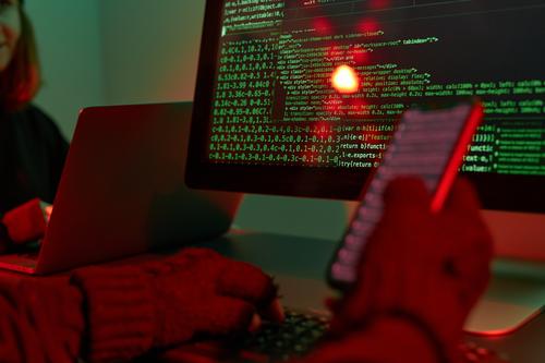 Cyber-Angriff. Hacker brechen die Sicherheit. Anonyme Personen greifen auf geheime Daten zu. Cyber-Krieg. Anonyme Personen benutzen Computer und Programmierung, um den Code zu knacken. Zugang zu privaten Daten. Bedrohung der Cybersicherheit