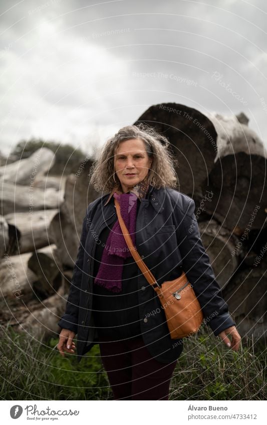 Eine Frau, 60 Jahre alt, mit grauen Haaren, stehend, genießt einen Spaziergang auf dem Land, im Frühling, in einer ländlichen Gegend der Region Campo de Borja, Provinz Zaragoza, Aragonien, Spanien
