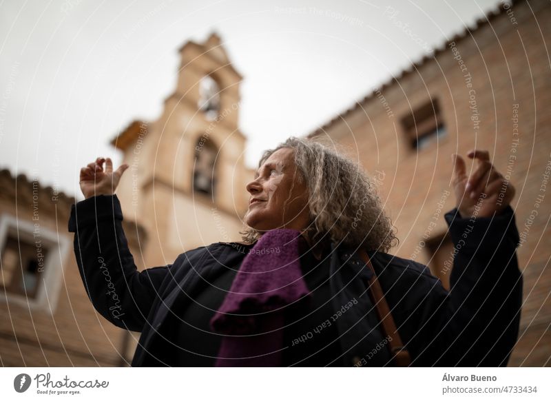 Eine Frau mit grauen Haaren genießt die Architektur und die Aussicht vom Glockenturm der Kirche der Heimsuchung in Malejan während eines Landausflugs in Aragonien, Spanien