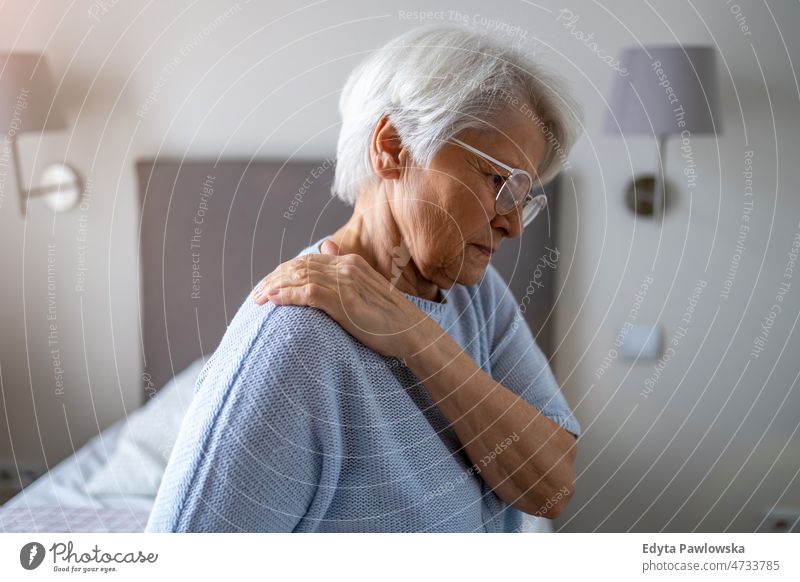 Ältere Frau leidet unter Rückenschmerzen allein zu Hause häusliches Leben älter Oma Großmutter graue Haare heimwärts im Innenbereich Lifestyle reif alt
