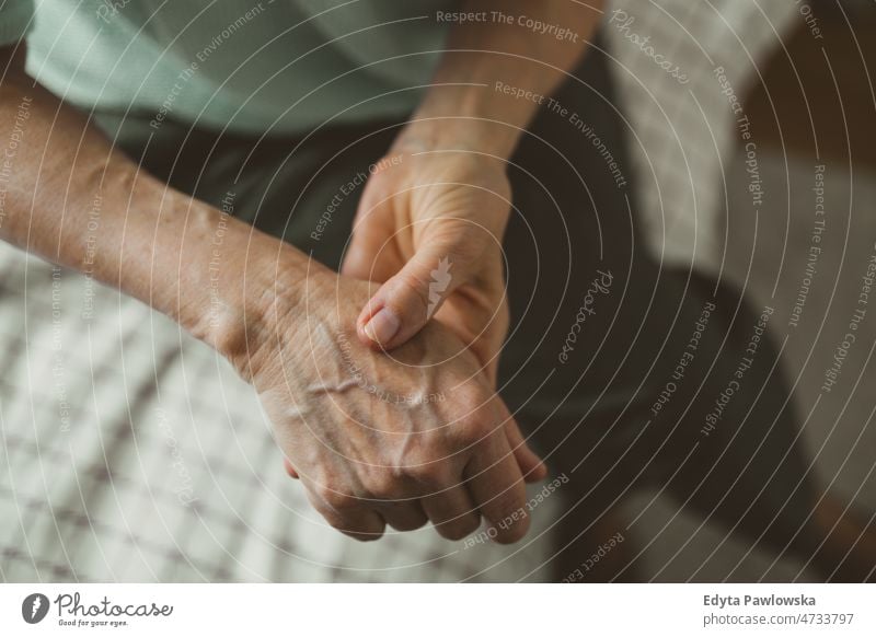 Ältere Frau mit Arthritis reibt sich die Hände Rheumatismus steif Verbindungen steife Gelenke massierend Handgelenk Osteoporose faltige Haut Falte abschließen