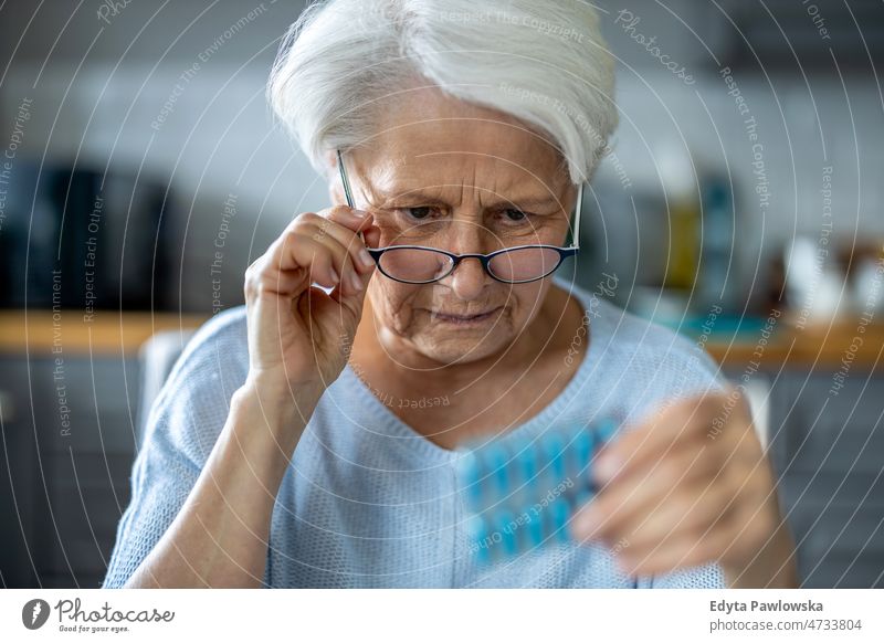 Ältere Frau vor der Einnahme ihrer Medikamente Pillen Brille lesen Medizin Verschreibung Behandlung Vitamin Einnahme von Medikamenten Apotheke