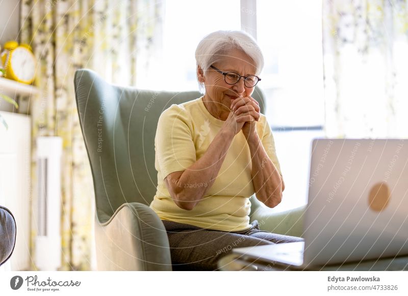 Ältere Frau benutzt Laptop zu Hause Brille allein häusliches Leben älter Oma Großmutter graue Haare heimwärts im Innenbereich Lifestyle reif alt eine Person