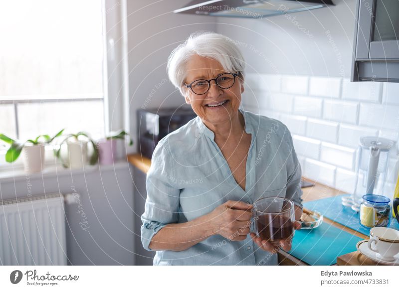 Aufnahme einer älteren Frau in ihrer Küche allein zu Hause häusliches Leben Oma Großmutter graue Haare heimwärts im Innenbereich Lifestyle reif alt eine Person