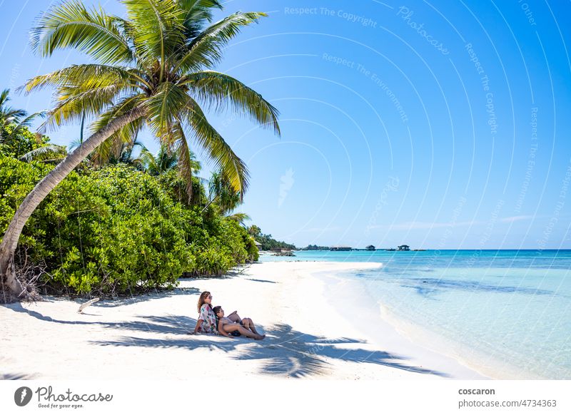 Frau und Kind liegen im Schatten einer Palme an einem weißen Sandstrand Hintergrund Strand Junge Karibik Kaukasier Küste Küstenlinie Kokosnuss Menschenleer