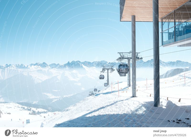 Gipfelstation einer Gondelbahn mit Blick auf ein schneebedecktes Alpenpanorama Landschaft Gebirge Panorama Winter Schnee weiß blau Ferne Wintersport Lift