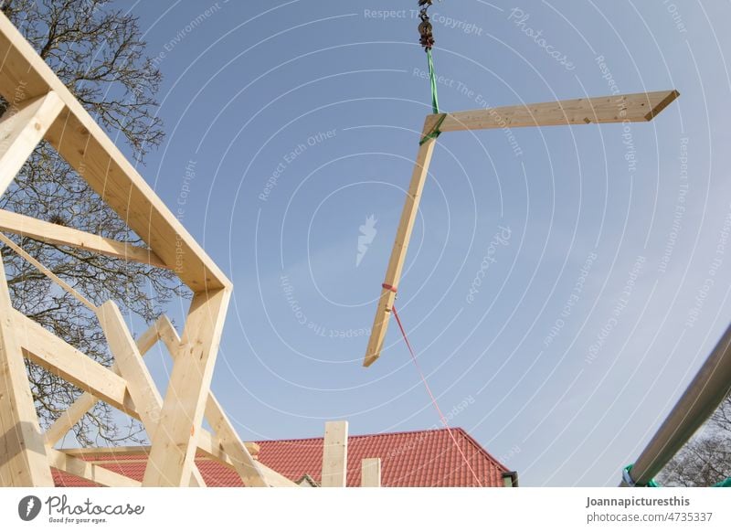 Dachbalken wird mit Kran durch die Luft transportiert Balken Holz zimmermann Handwerk Hausbau Baustelle Außenaufnahme bauen Arbeit & Erwerbstätigkeit Bauwerk
