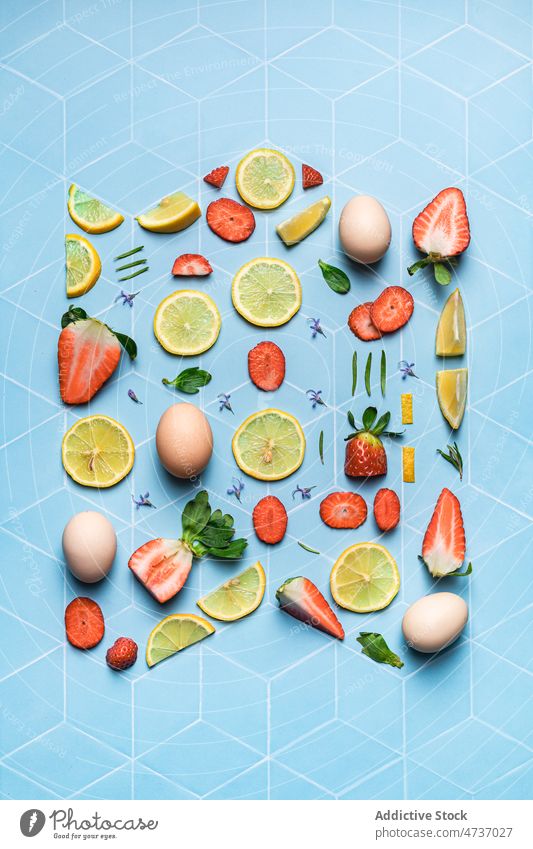 Komposition von Früchten Beeren und Eier auf geometrischem Hintergrund Zitrone Kalk flache Verlegung Erdbeeren kreativ Scheibe frisch Zusammensetzung Spielfigur