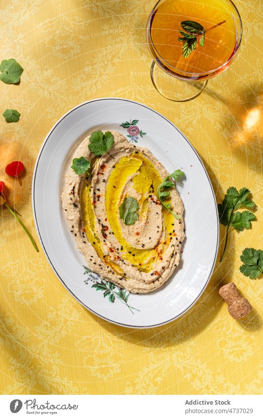 Hummus auf Teller serviert mit einem Glas Wein Bohnenkraut Kichererbsen zerschlagen Erdöl oliv dienen Speise lecker Lebensmittel Gesundheit Portion