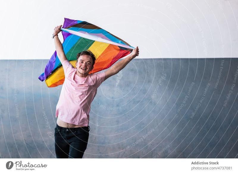Aufgeregte Transgender-Person mit LGBT-Flagge lgbt lgbtq Fahne springen Symbol queer Identität Toleranz Stolz diskriminieren Geschlecht Minderheit Regenbogen