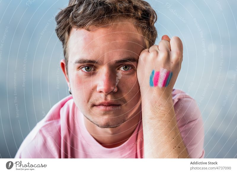 Mann zeigt Hand mit Transgender-Flagge Fahne Symbol Identität unkonventionell gleich Respekt Aktivismus alternativ Streifen farbenfroh kreativ mehrfarbig Raum