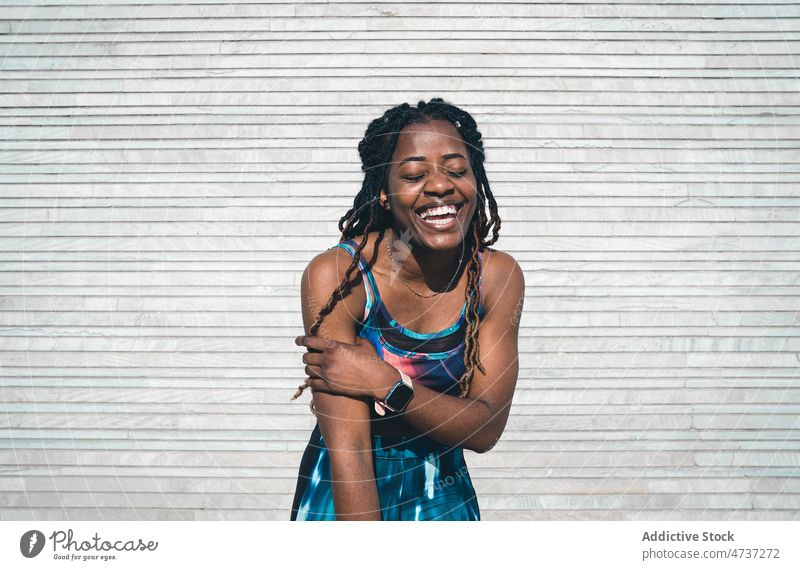 Fröhliche schwarze Frau in Sportkleidung auf der Strandpromenade nach dem Training Lachen Glück Fitness Freude Wellness Gesunder Lebensstil üben Laufsteg