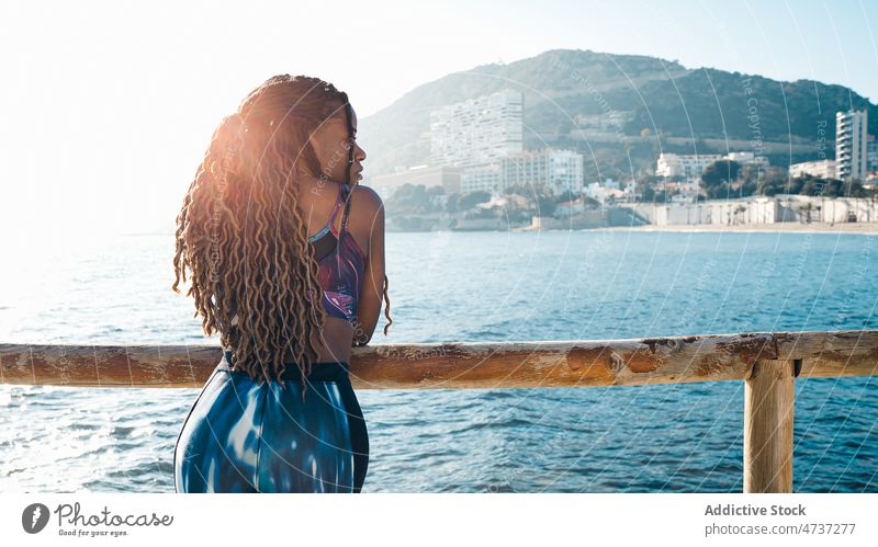 Schwarze Frau in Sportkleidung lehnt an einem Zaun an der Uferböschung Stauanlage passen MEER Training nachdenklich Wellness Gesundheit sportlich ernst