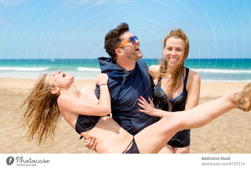 Fröhliche Freunde haben Spaß am Sandstrand im Urlaub Mann Frauen Lachen Strand Freude Glück Spaß haben MEER männlich Meeresufer heiter Küste fliegendes Haar