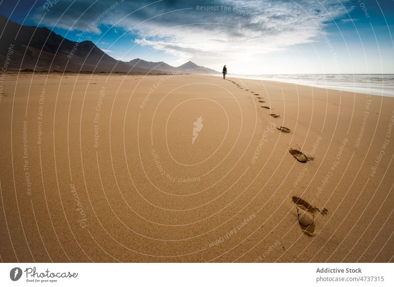 Person, die am Sandstrand spazieren geht, umgeben von Hügeln Reisender Strand Freiheit Fußspur Küste Ausflug MEER Urlaub Harmonie Ufer Silhouette Meeresufer