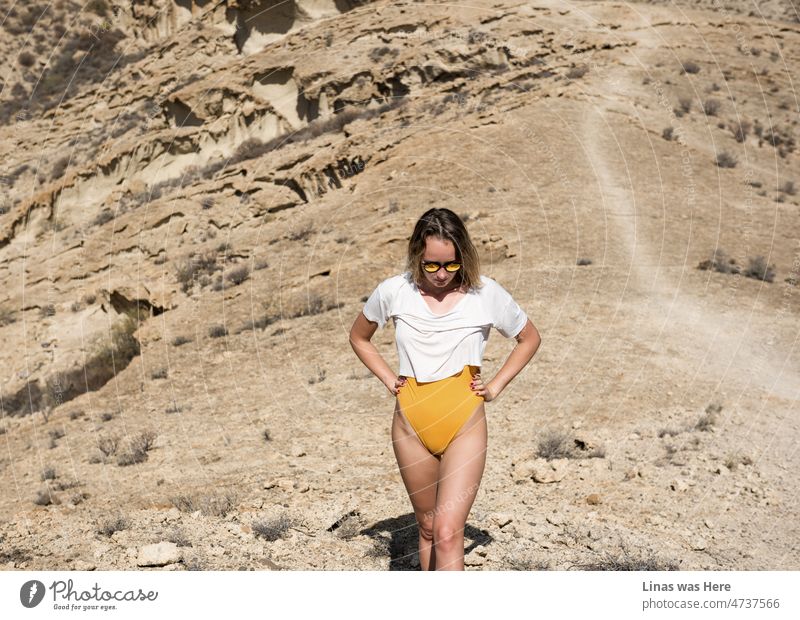 Ein malerischer Ort auf Teneriffa mit einem hübschen Mädchen im Urlaub. Sand, Felsen und Steine umgeben sie auf diesem Weg. Auf dem Weg zu einem tollen Ort!