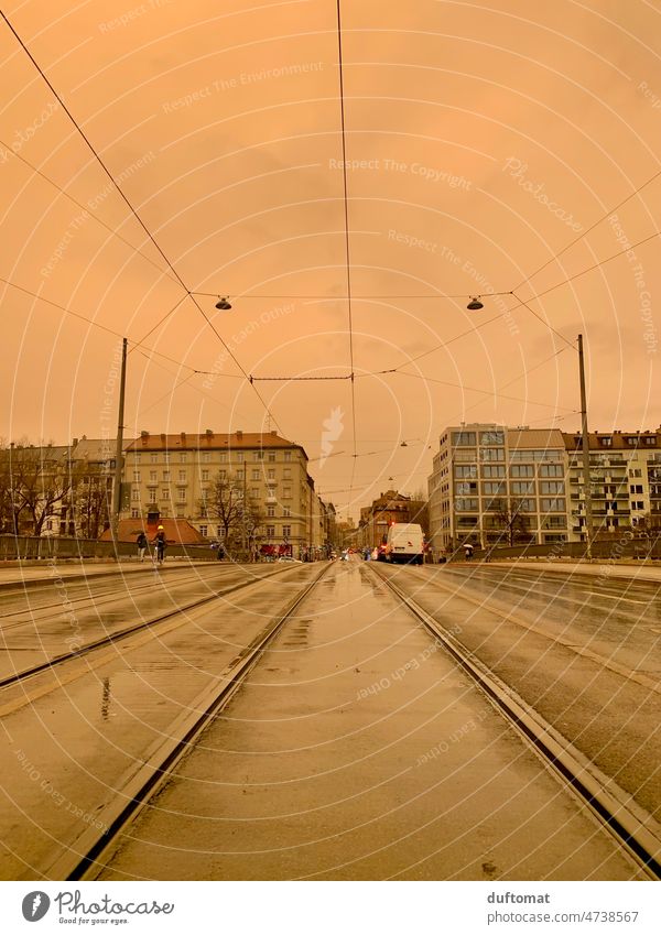 Sahara Staub bei Regen auf Straßenbahngleisen in München orange Stadtleben Saharastaub Luft Wetter Wetterphänomen Sand Himmel nass Gleise Bahngleis Transport