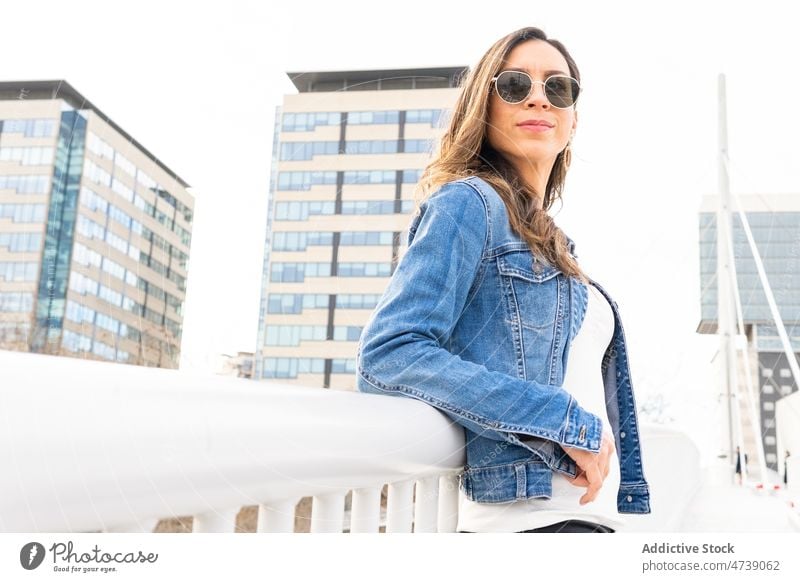 Stilvolle Frau mit Sonnenbrille in der Stadt Straße Outfit Großstadt trendy urban Mode feminin Vorschein Bekleidung Jacke Kleidungsstück Dame anhaben attraktiv