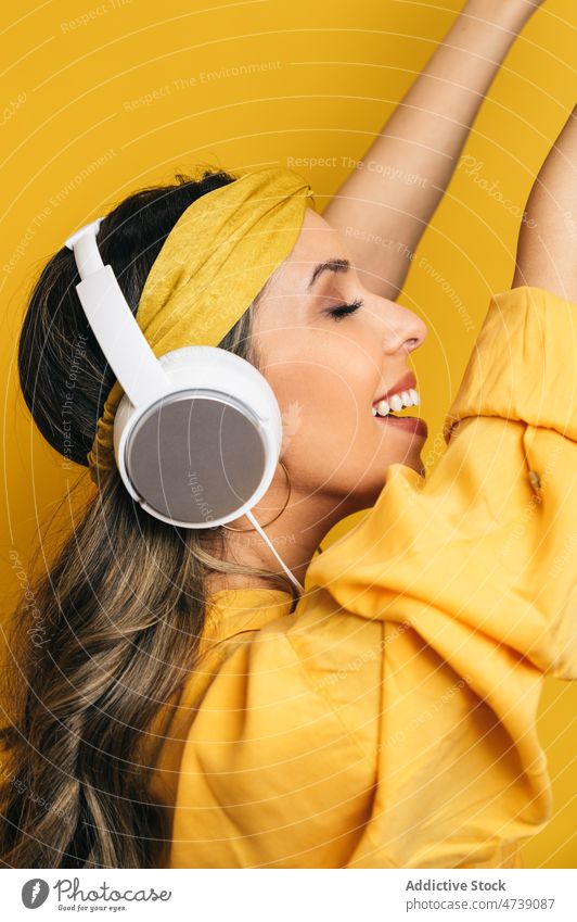 Zufriedene Frau, die mit Kopfhörern Musik hört zuhören Glück Tanzen hell Stil cool Freizeit redaktionell heiter farbenfroh Freude Energie positiv Hobby Make-up