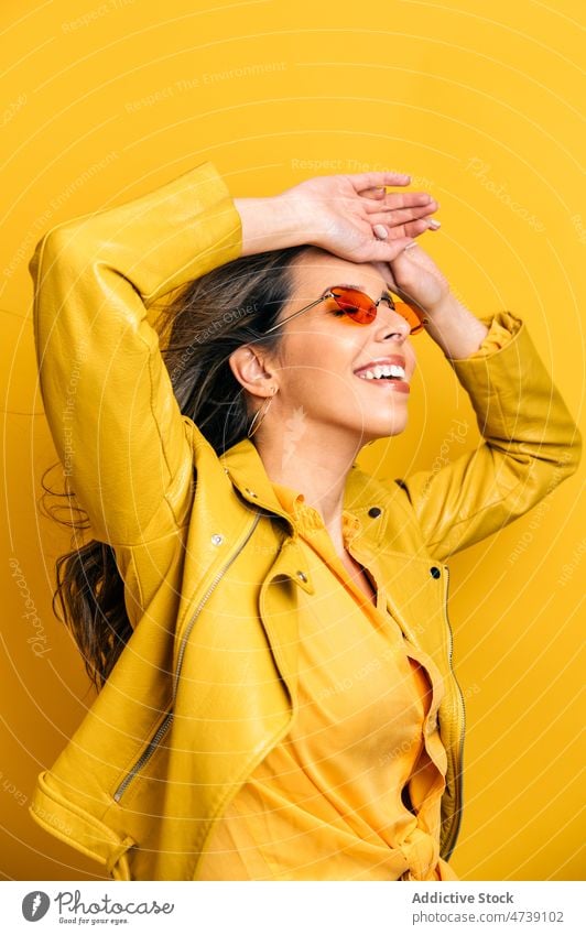 Lächelnde moderne Frau mit langen fliegenden Haaren im Studio Glück Bewegung wallendes Haar Stil cool hell angenehm Wind sorgenfrei Model redaktionell Vorschein