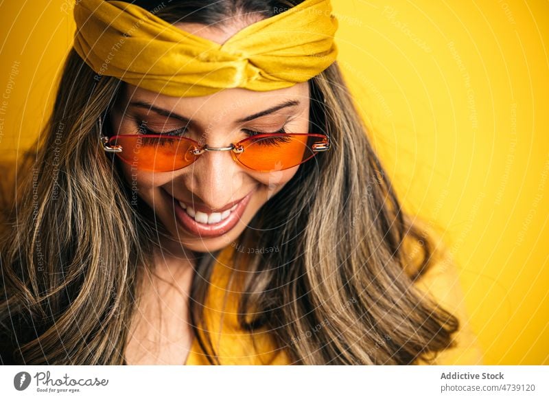 Lächelnde stilvolle Frau mit trendiger Sonnenbrille und Stirnband Model Individualität Glück Vorschein cool feminin Stil Porträt redaktionell pulsierend lebhaft