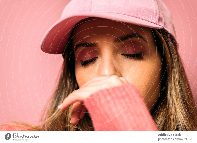 Frau mit Mütze und geschlossenen Augen Stil Make-up feminin rosa Design trendy Mode Vorschein Verschlussdeckel Kosmetik Windstille Augen geschlossen Atelier