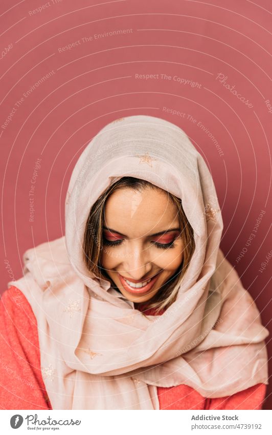 Attraktive arabische Frau mit Kopftuch im Studio rosa Stil Make-up feminin Design Deckblatt Rätsel Tierhaut trendy Vorschein Windstille Augen geschlossen