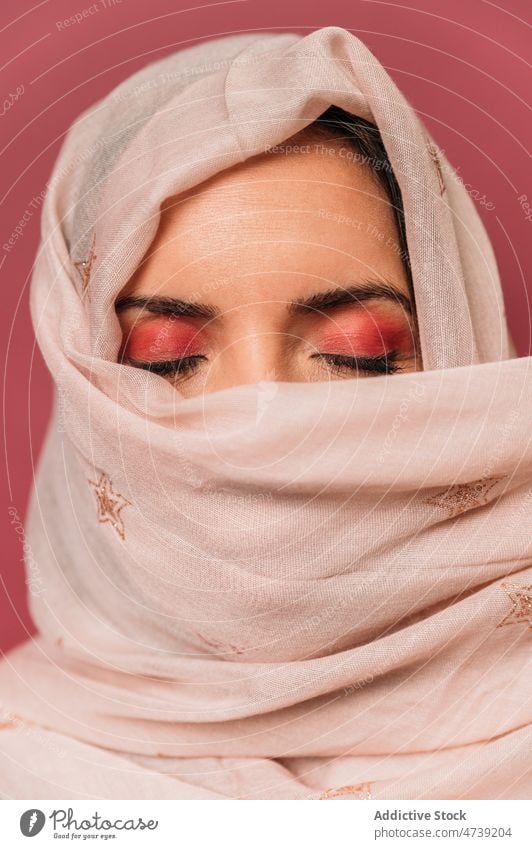 Attraktive muslimische Frau mit Kopftuch im Studio rosa Stil Make-up feminin Design Deckblatt Rätsel Tierhaut trendy Vorschein Windstille Augen geschlossen