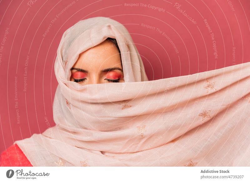 Attraktive muslimische Frau mit Kopftuch im Studio rosa Stil Make-up feminin Design Deckblatt Rätsel Tierhaut trendy Vorschein Windstille Augen geschlossen