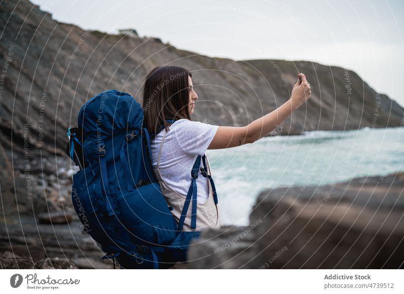 Wanderin beim Fotografieren des Meeres Frau Wanderer Trekking MEER Wasser Selfie Abenteuer Selbstportrait fotografieren soziale Netzwerke Smartphone Hafengebiet
