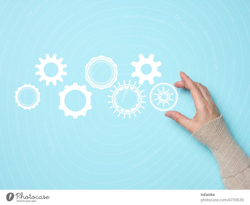 Zahnräder und weibliche Hand auf einem blauen Hintergrund. Business-Struktur präzise Arbeit Konzept, Team-Einigung Arme Zahnrad Anschluss Kontrolle