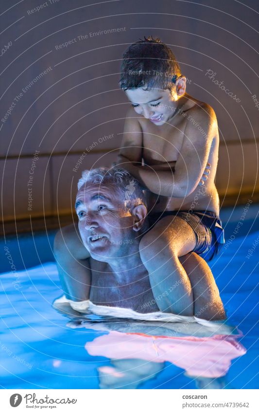 Großvater und Enkel spielen nachts in einem Schwimmbad aktiv Aktivität Erwachsener Baby Junge Kaukasier heiter Kind Kindheit niedlich älter genießen Abend