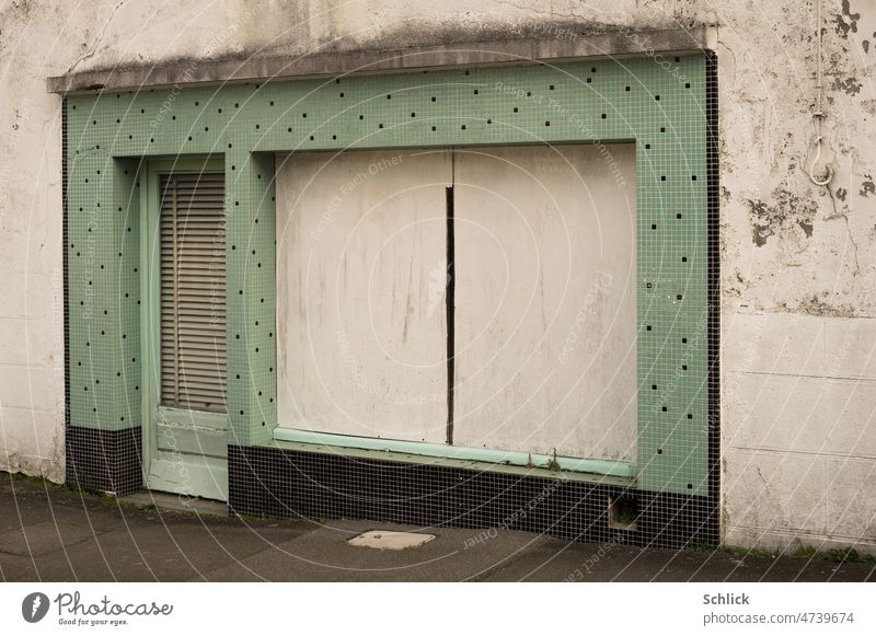 Zu, Schaufenster eines Ladengeschäfts mit Spanplatten verdeckt geschlossen Architektur Außenaufnahme Kacheln klein grün alt marode Farbfoto Fassade Gebäude