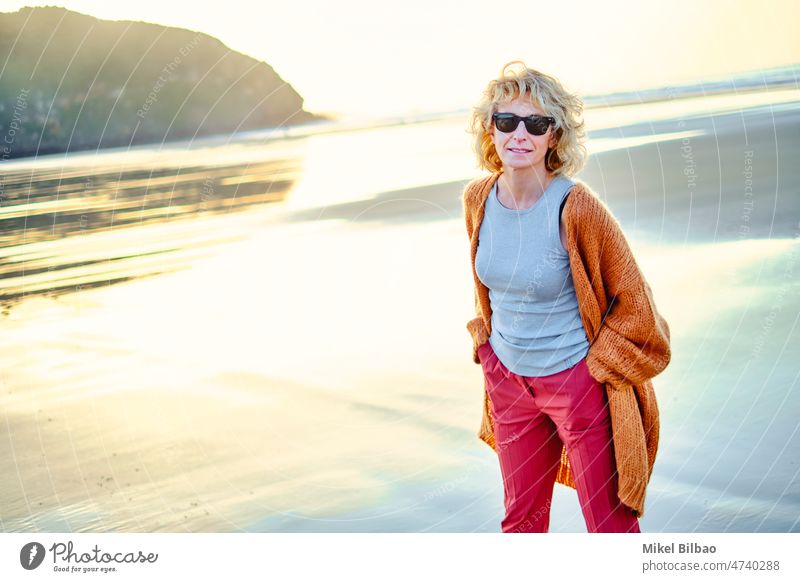 Junge reife blonde kaukasische Frau im Freien in einem Strand in einem sonnigen Tag. Lifestyle-Konzept. Porträt Wellness Frauen Gesundheit Erholung