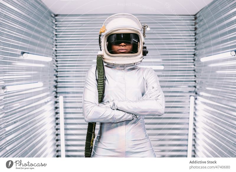 Anonymer schwarzer Astronaut in leichtem Raumschiff Frau Raumanzug Schutzhelm Kosmonaut Tracht Missionsstation Uniform modern Sicherheit Afroamerikaner Licht