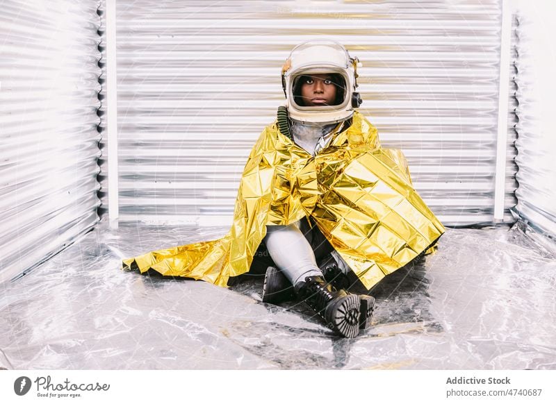 Schwarzer Astronaut eingewickelt in Emergenz-Decke Frau Raumanzug Schutzhelm Raumschiff Kosmonaut Notfall thermisch Sicherheit Tracht Missionsstation Überleben
