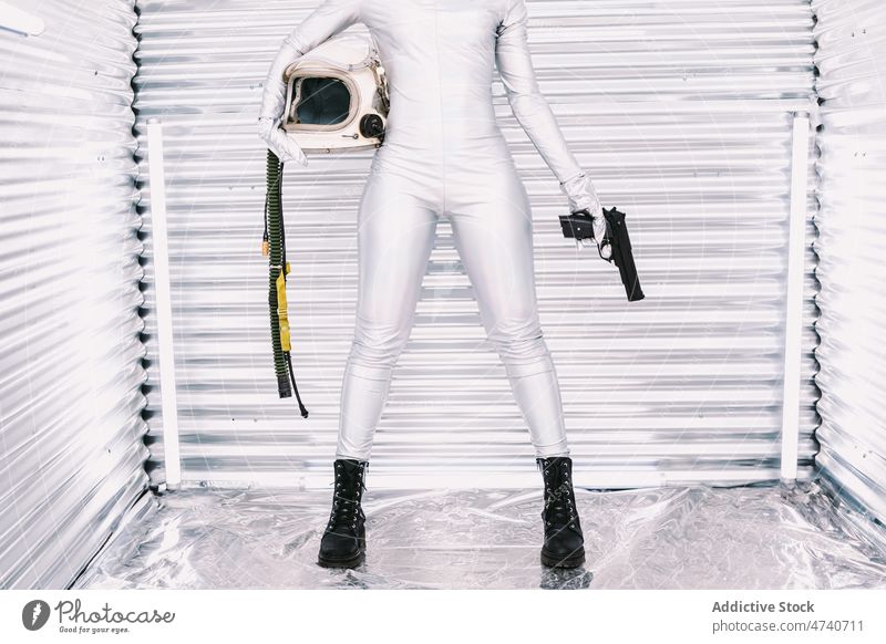 Anonymer schwarzer Kosmonaut mit Waffe im Raumschiff Frau Raumanzug Astronaut Pistole gefährlich Tracht Mut Missionsstation Uniform modern Sicherheit