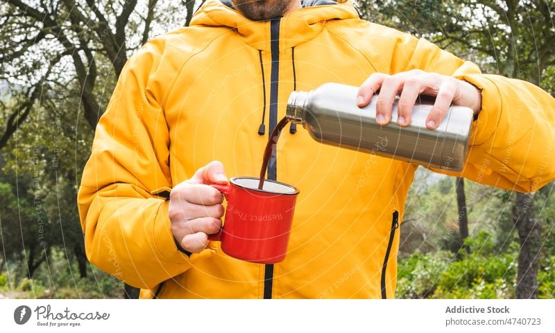 Anonymer Mann gießt Kaffee in die Natur Thermoskanne Heißgetränk Wanderer Trekking Reise Wald Getränk eingießen erkunden Ausflug Wanderung Wälder Aktivität